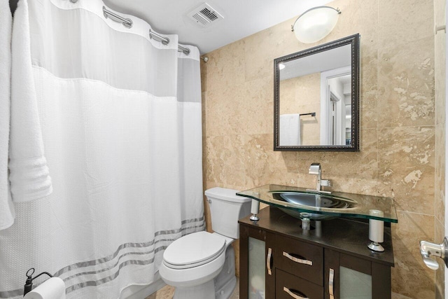4511 S Ocean Blvd Unit 106, Highland Beach, FL 33487 - full bathroom with tile walls, toilet, vanity, and a shower with shower curtain