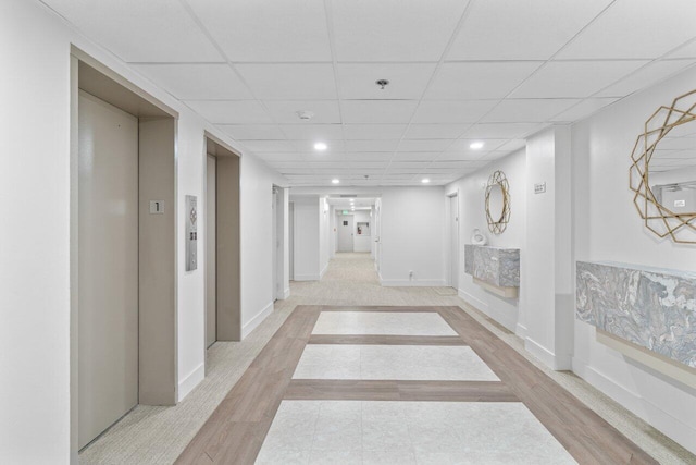 4511 S Ocean Blvd Unit 106, Highland Beach, FL 33487 - corridor with elevator, a drop ceiling, recessed lighting, baseboards, and light wood-style flooring