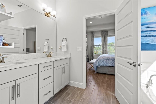17936 Adrift Rd, Winter Garden, FL 34787 - ensuite bathroom with double vanity, wood finished floors, baseboards, and recessed lighting