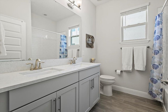 17936 Adrift Rd, Winter Garden, FL 34787 - full bath with double vanity, toilet, baseboards, wood finished floors, and shower / bath combo