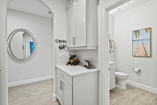 17936 Adrift Rd, Winter Garden, FL 34787 - bathroom with baseboards, decorative backsplash, wood finished floors, and vanity