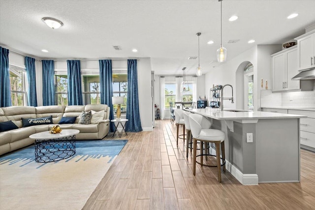17936 Adrift Rd, Winter Garden, FL 34787 - living room with light wood-style flooring, arched walkways, recessed lighting, and baseboards