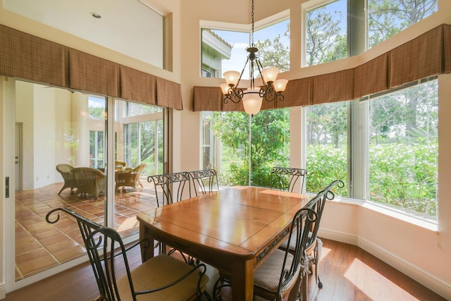 13312 NW Maplewood Rd, Palm City, FL 34990 - dining room with plenty of natural light, a towering ceiling, wood finished floors, a chandelier, and baseboards