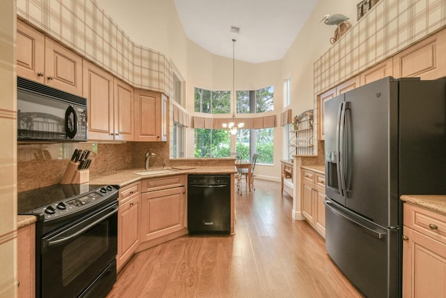 13312 NW Maplewood Rd, Palm City, FL 34990 - kitchen with black appliances, a sink, a chandelier, light wood-type flooring, and light countertops