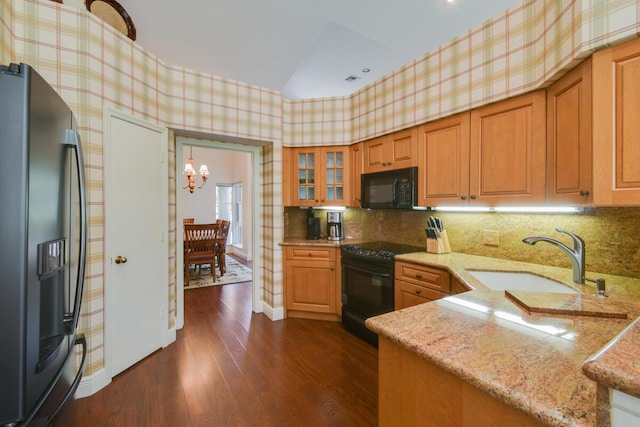13312 NW Maplewood Rd, Palm City, FL 34990 - kitchen featuring black appliances, a sink, wallpapered walls, light stone countertops, and dark wood-type flooring
