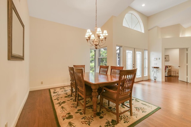 13312 NW Maplewood Rd, Palm City, FL 34990 - dining space with a chandelier, baseboards, wood finished floors, recessed lighting, and a towering ceiling