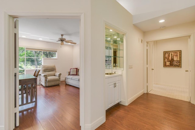 13312 NW Maplewood Rd, Palm City, FL 34990 - hall featuring wood finished floors, baseboards, recessed lighting, and a sink