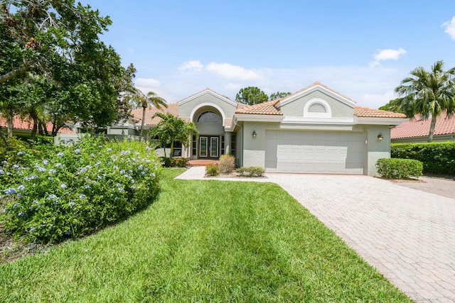 13312 NW Maplewood Rd, Palm City, FL 34990 - mediterranean / spanish home featuring french doors, stucco siding, an attached garage, a front yard, and decorative driveway