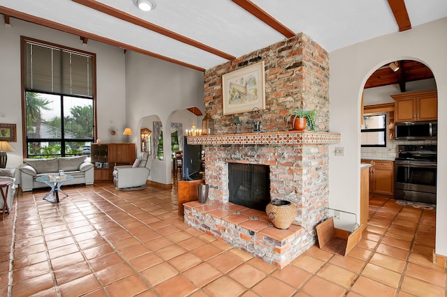 5898 Vista Linda Ln, Boca Raton, FL 33433 - living room with arched walkways, a brick fireplace, healthy amount of natural light, and light tile patterned flooring