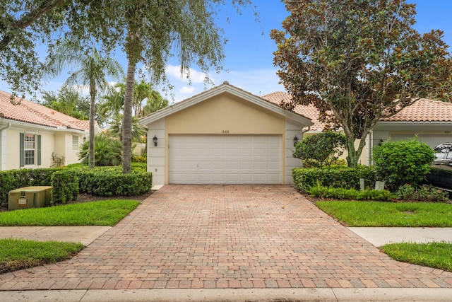 649 Hudson Bay Dr, Palm Beach Gardens, FL 33410 - view of front facade featuring decorative driveway, stucco siding, and an attached garage