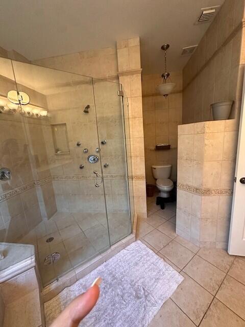 9202 Olmstead Dr, Lake Worth, FL 33467 - bathroom featuring toilet, tile patterned floors, a stall shower, and tile walls