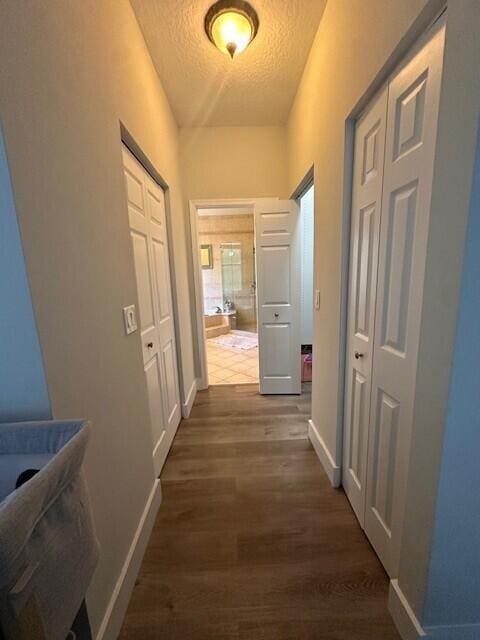 9202 Olmstead Dr, Lake Worth, FL 33467 - hallway featuring a textured ceiling, dark wood-style flooring, and baseboards