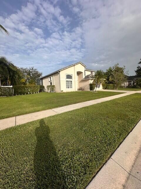 9202 Olmstead Dr, Lake Worth, FL 33467 - view of property exterior with a lawn and stucco siding