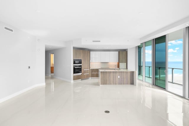3100 N Ocean Dr Unit H-1708, Singer Island, FL 33404 - kitchen with modern cabinets, black appliances, light countertops, baseboards, and open floor plan