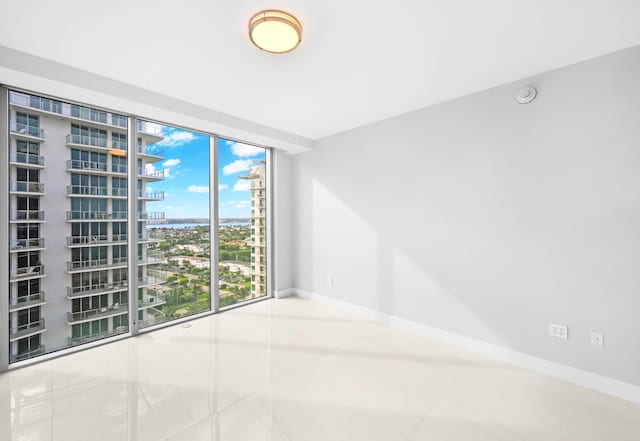 3100 N Ocean Dr Unit H-1708, Singer Island, FL 33404 - tiled empty room featuring baseboards, a city view, and a smoke detector
