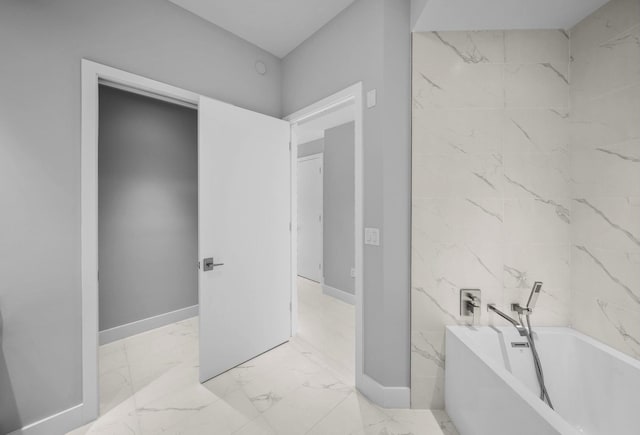 3100 N Ocean Dr Unit H-1708, Singer Island, FL 33404 - bathroom with a freestanding bath, marble look tiles, and baseboards