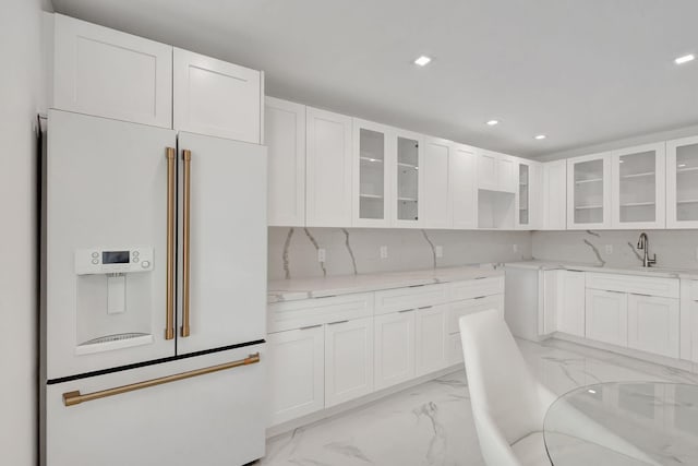 20 Somerset Unit A, West Palm Beach, FL 33417 - kitchen featuring high end white fridge, light marble finish floors, white cabinets, recessed lighting, and glass insert cabinets