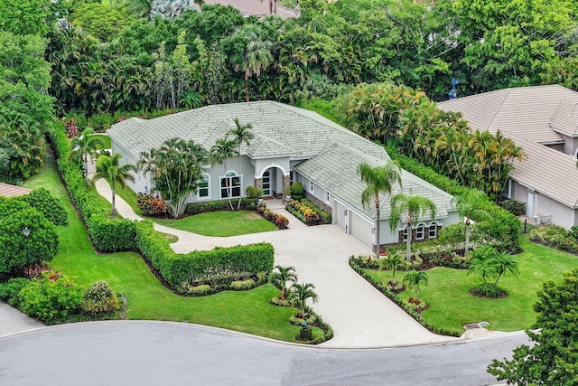 7815 Fairway Ln, West Palm Beach, FL 33412 - view of front of house with stucco siding, decorative driveway, an attached garage, and a front lawn