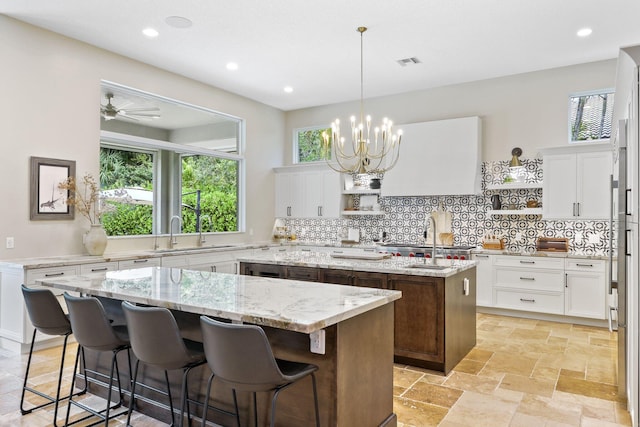 7815 Fairway Ln, West Palm Beach, FL 33412 - kitchen featuring a center island, a sink, decorative backsplash, white cabinets, and recessed lighting