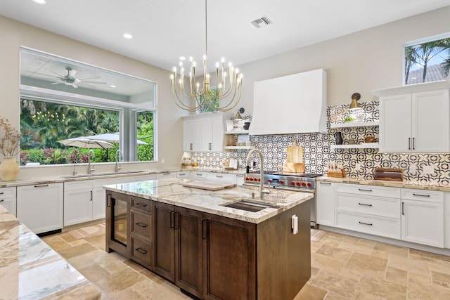7815 Fairway Ln, West Palm Beach, FL 33412 - kitchen featuring open shelves, a sink, stone tile flooring, white cabinets, and recessed lighting