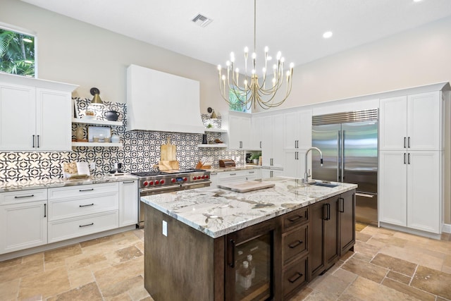 7815 Fairway Ln, West Palm Beach, FL 33412 - kitchen with open shelves, premium appliances, a sink, wine cooler, and white cabinetry