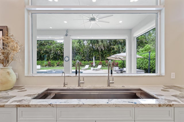 7815 Fairway Ln, West Palm Beach, FL 33412 - kitchen with a sink, healthy amount of natural light, white cabinets, light stone counters, and recessed lighting