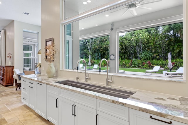 7815 Fairway Ln, West Palm Beach, FL 33412 - kitchen with a sink, light stone finish flooring, white cabinets, light stone countertops, and recessed lighting