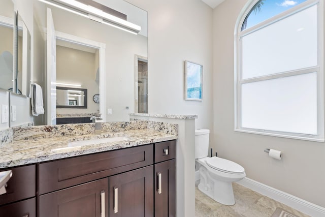 7815 Fairway Ln, West Palm Beach, FL 33412 - full bathroom with toilet, vanity, plenty of natural light, and baseboards