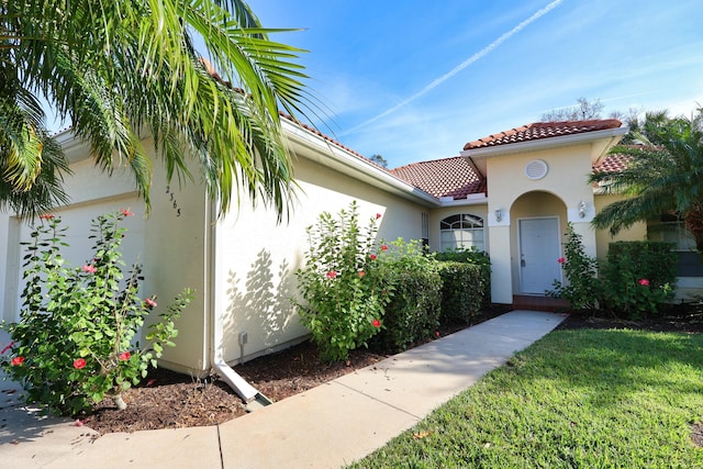 2365 55th Sq, Vero Beach, FL 32966 - property entrance with stucco siding and a tiled roof