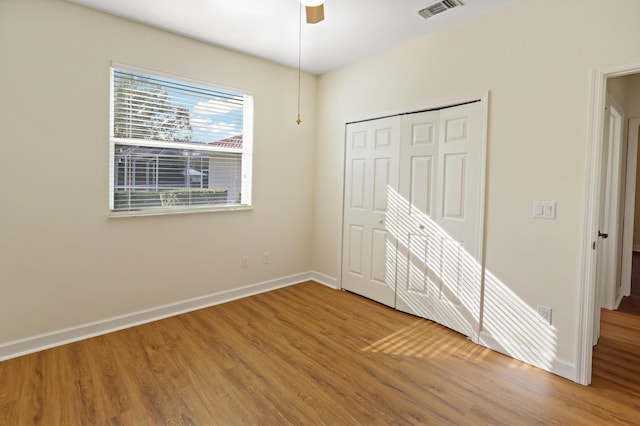 2365 55th Sq, Vero Beach, FL 32966 - unfurnished bedroom with wood finished floors, baseboards, a closet, and a ceiling fan