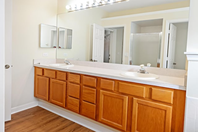 2365 55th Sq, Vero Beach, FL 32966 - bathroom featuring a shower stall, double vanity, wood finished floors, and baseboards