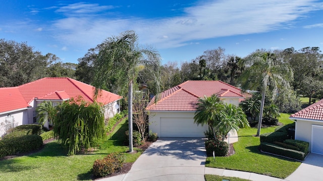 2365 55th Sq, Vero Beach, FL 32966 - mediterranean / spanish house featuring a tile roof, concrete driveway, a front lawn, stucco siding, and an attached garage
