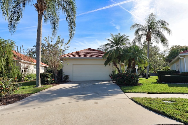 2365 55th Sq, Vero Beach, FL 32966 - mediterranean / spanish-style home with driveway, a tile roof, a front yard, stucco siding, and a garage