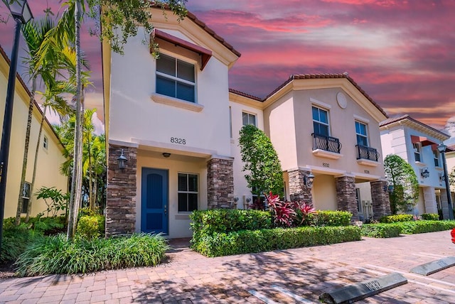 8328 Cocoplum Sound Ln, West Palm Beach, FL 33411 - view of front of house featuring stone siding, stucco siding, and a tiled roof