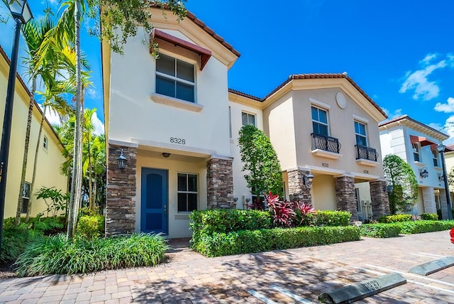 8328 Cocoplum Sound Ln, West Palm Beach, FL 33411 - view of front of house with stone siding, stucco siding, and a tile roof