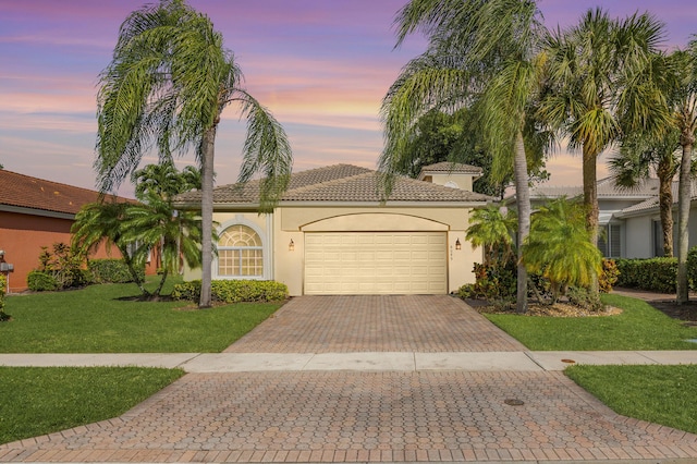 8089 Brindisi Ln, Boynton Beach, FL 33472 - mediterranean / spanish house with decorative driveway, an attached garage, stucco siding, a front yard, and a tiled roof