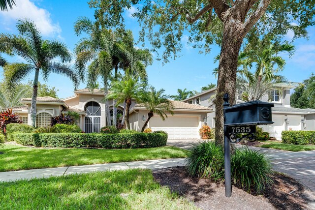 7535 Tarpon Cove Cir, Lake Worth, FL 33467 - view of front of property featuring an attached garage, stucco siding, and concrete driveway