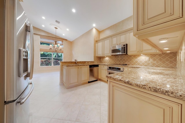 7535 Tarpon Cove Cir, Lake Worth, FL 33467 - kitchen featuring cream cabinets, stainless steel appliances, a peninsula, backsplash, and light stone counters