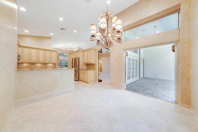 7535 Tarpon Cove Cir, Lake Worth, FL 33467 - kitchen featuring freestanding refrigerator, cream cabinetry, a chandelier, decorative backsplash, and open floor plan