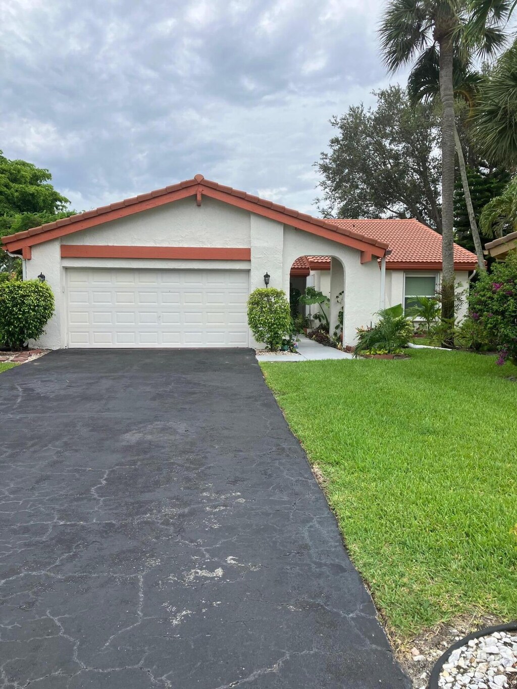 5735 Lakeview Mews Cir, Boynton Beach, FL 33437 - view of front of house with stucco siding, asphalt driveway, a tiled roof, and a garage