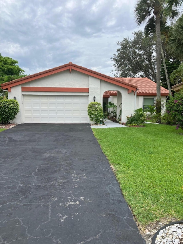 5735 Lakeview Mews Cir, Boynton Beach, FL 33437 - view of front of house with stucco siding, asphalt driveway, a tiled roof, and a garage