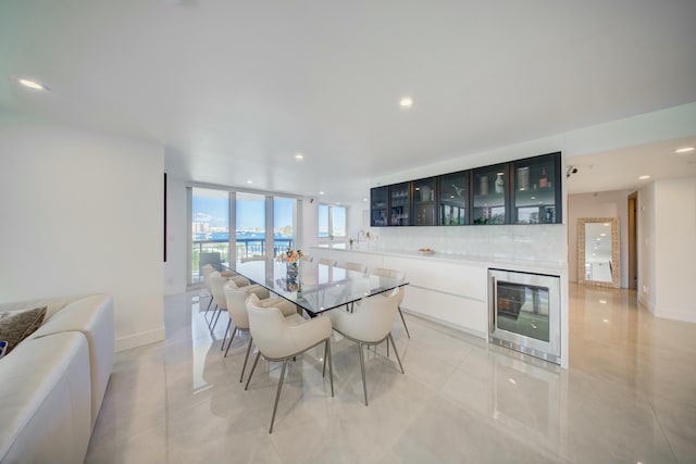 901 E Camino Real Unit 2A, Boca Raton, FL 33432 - dining space with wine cooler, light tile patterned flooring, recessed lighting, baseboards, and floor to ceiling windows