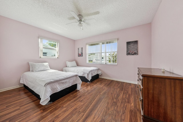 1803 SW 5th Ave, Boynton Beach, FL 33426 - bedroom featuring multiple windows, dark wood finished floors, a textured ceiling, a ceiling fan, and baseboards