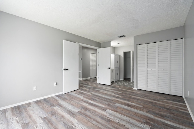 2307 SE Seafury Ln SE, Port Saint Lucie, FL 34952 - unfurnished bedroom with wood finished floors, baseboards, and a textured ceiling