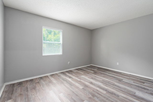 2307 SE Seafury Ln SE, Port Saint Lucie, FL 34952 - unfurnished room featuring wood finished floors, baseboards, and a textured ceiling