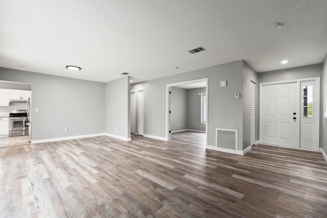 2307 SE Seafury Ln SE, Port Saint Lucie, FL 34952 - unfurnished living room with wood finished floors, baseboards, and a textured ceiling