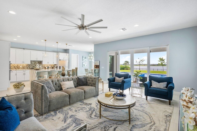 983 Hookline Cir, The Acreage, FL 33470 - living area featuring recessed lighting, ceiling fan, light tile patterned floors, and a textured ceiling