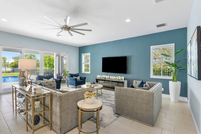 983 Hookline Cir, The Acreage, FL 33470 - living area featuring plenty of natural light, a ceiling fan, a textured ceiling, recessed lighting, and baseboards