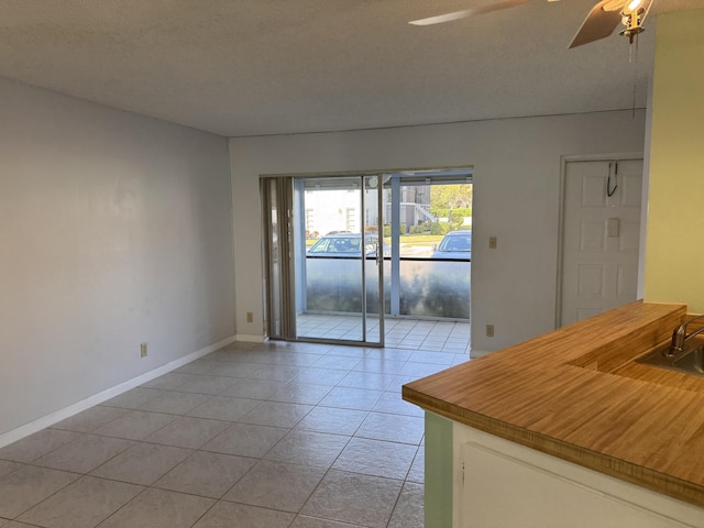 7535 S Orile Blvd Unit 108, Delray Beach, FL 33446 - unfurnished dining area featuring ceiling fan, light tile patterned floors, baseboards, and a sink