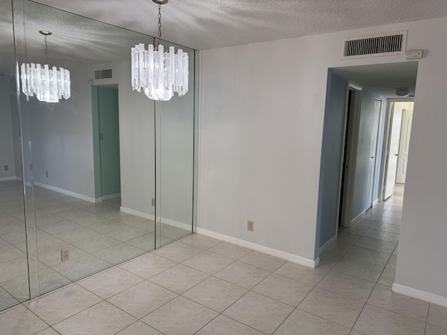 7535 S Orile Blvd Unit 108, Delray Beach, FL 33446 - spare room featuring a chandelier, a textured ceiling, light tile patterned floors, and baseboards